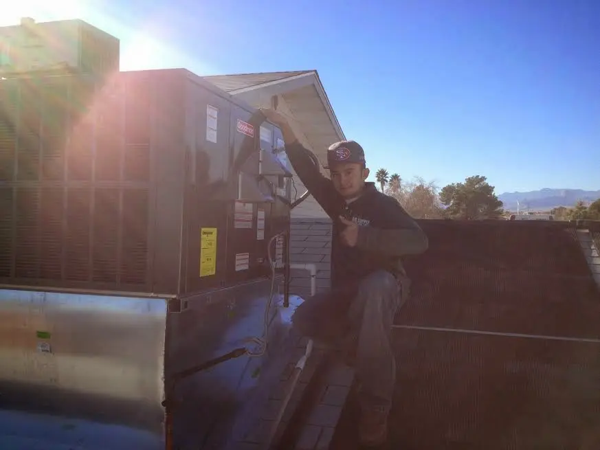 HVAC technician performing HVAC Inspection on a rooftop unit in Decatur